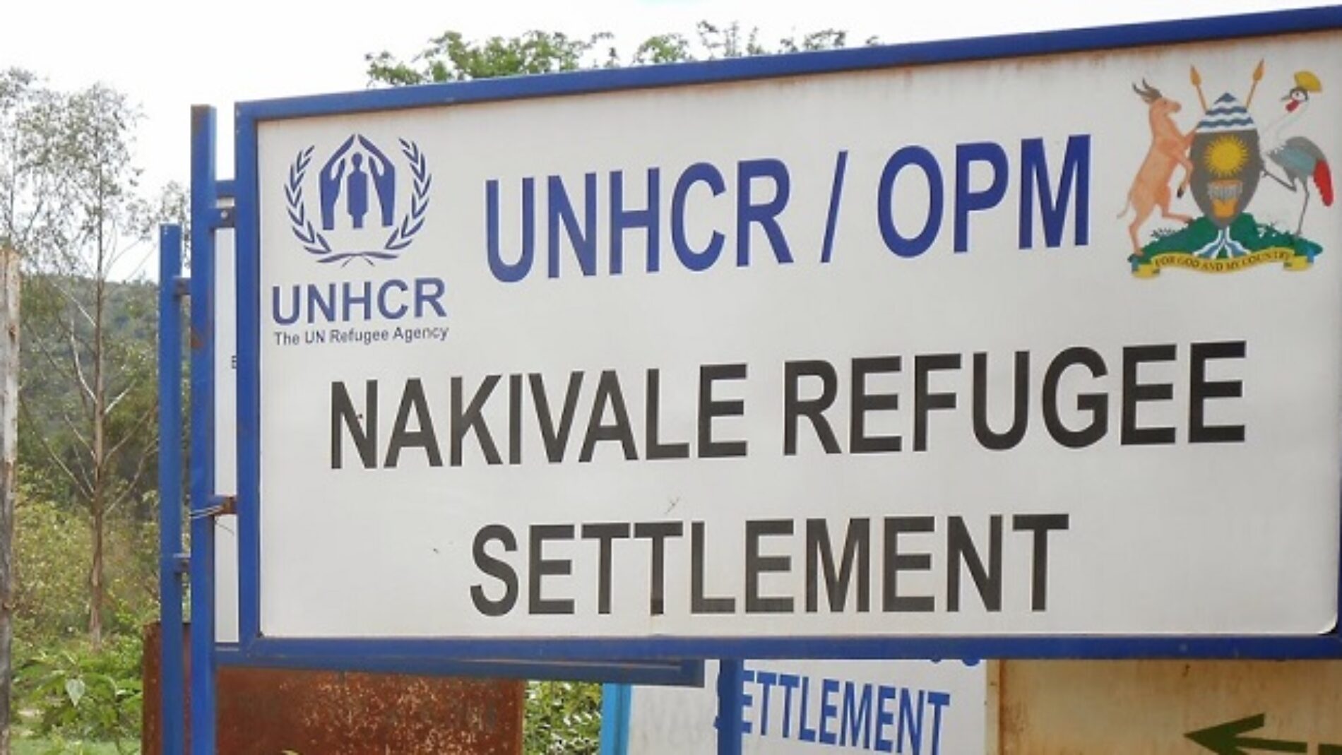 A UNHCR and Office of the Prime Minister sign at the entrance to Nakivale Refugee Settlement.